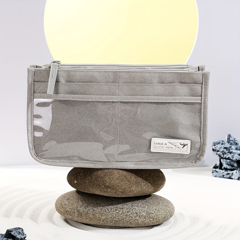 Pochette trasparente grigia su pietre, design minimalista, ideale per viaggi. Accessorio moda elegante, pratico e versatile.