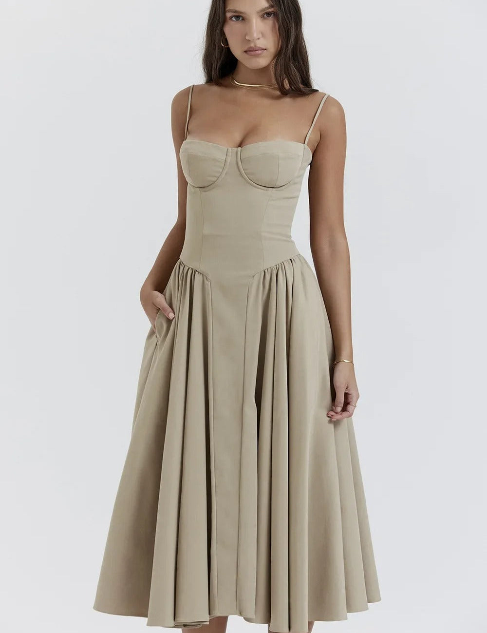 Abito midi beige elegante con spalline sottili e gonna ampia, indossato da modella. Perfetto per eventi formali e cerimonie.