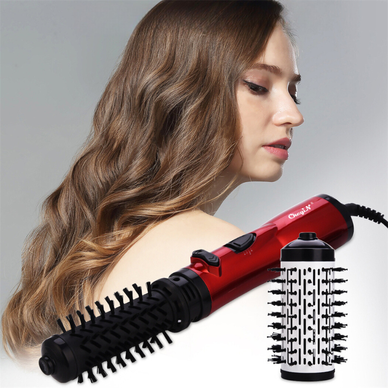Donna con capelli ondulati e spazzola rotante rossa per capelli. Strumento styling capelli, accessorio bellezza, acconciatura professionale.