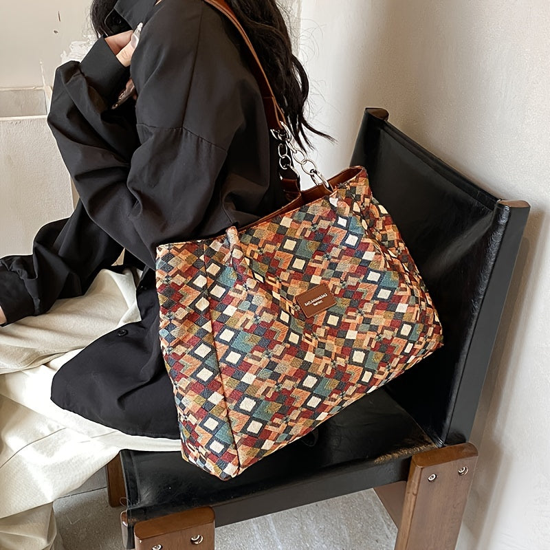 Borsa a tracolla multicolore con motivo geometrico, indossata da una persona seduta. Accessorio moda elegante, perfetto per ogni occasione.