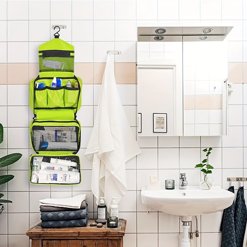 Organizer da bagno verde appeso, con scomparti per articoli da toeletta, su parete piastrellata bianca. Lavabo e specchio a destra.