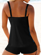 Donna in costume da bagno nero a due pezzi sulla spiaggia, top con spalline regolabili e pantaloncini. Moda mare, abbigliamento estivo donna.