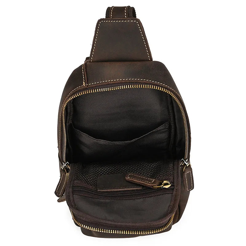 Zaino a tracolla in pelle marrone con cerniera aperta, tasche interne visibili. Design elegante e pratico per uomo e donna. Perfetto per viaggi e uso quotidiano.