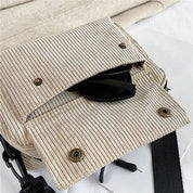 Borsa a tracolla in tessuto a coste beige con chiusura a bottoni, tracolla nera regolabile e occhiali da sole all'interno. Accessorio moda casual.