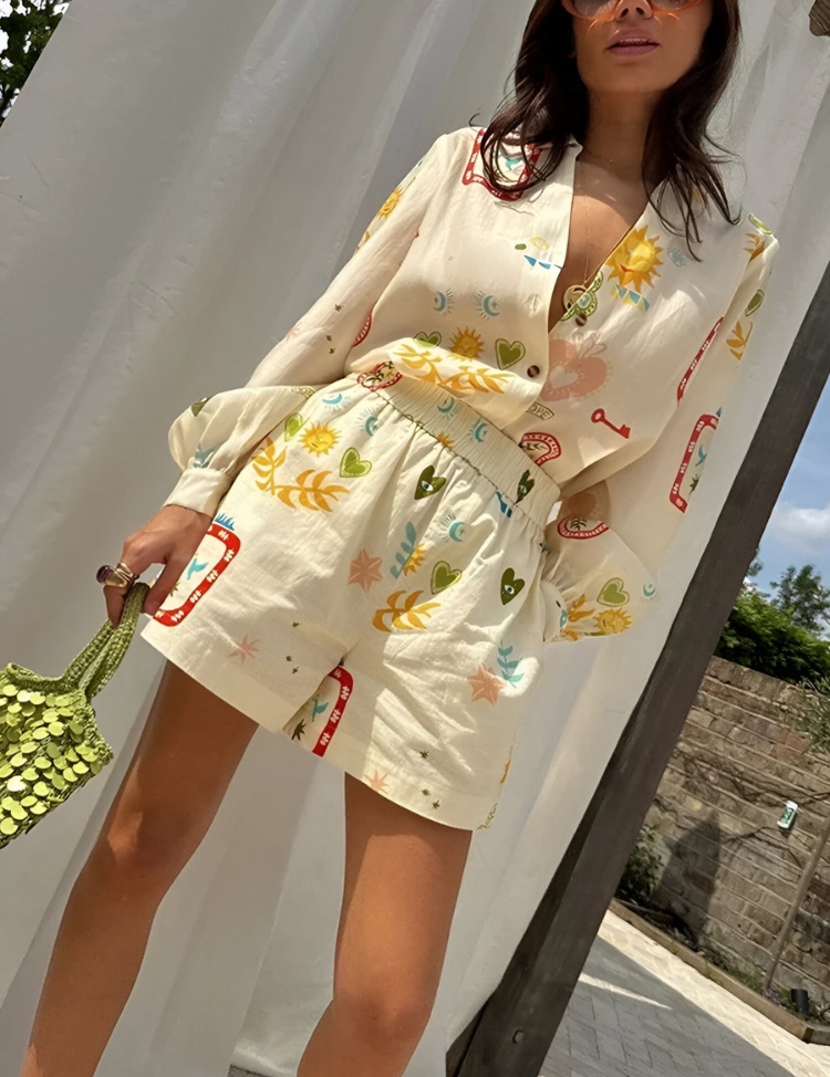 Donna con completo estivo in lino bianco stampato con motivi colorati, borsa verde a mano, sfondo esterno. Moda femminile, abbigliamento estivo.