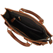 Borsa in pelle marrone con cerniera aperta, manici robusti, tasche interne e fodera nera. Elegante e spaziosa, ideale per lavoro e viaggio.