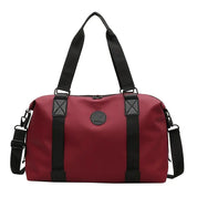 Borsone da viaggio rosso con manici e tracolla neri, design elegante e spazioso, ideale per palestra e weekend. Materiale resistente e impermeabile.