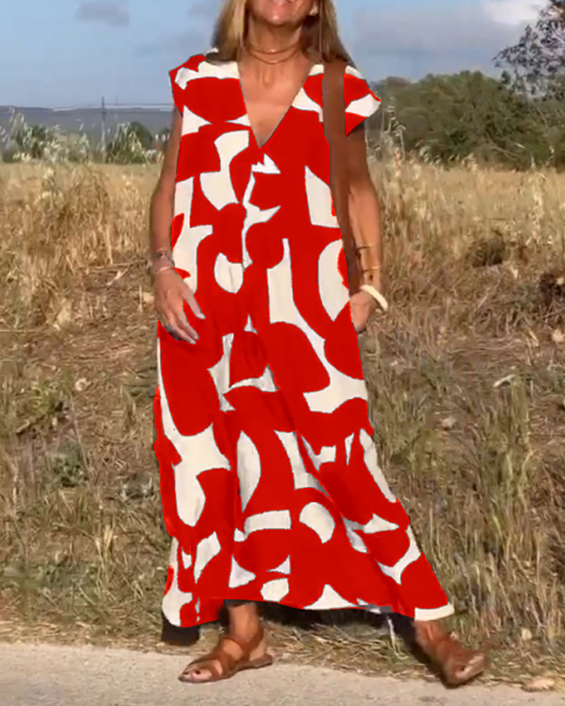 Abito lungo estivo rosso e bianco con motivo astratto, indossato da donna su strada di campagna. Stile casual, perfetto per giornate calde.