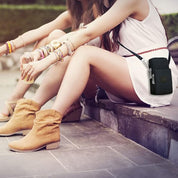 Due donne sedute con stivali beige e borsa a tracolla nera. Moda estiva, accessori colorati, abbigliamento casual.