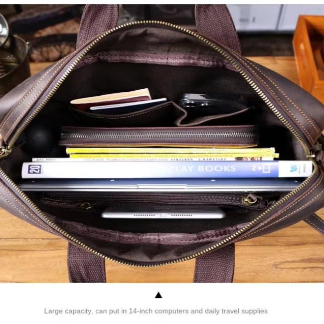 Borsa in pelle marrone aperta, mostra capacità interna con laptop, libri e accessori. Ideale per computer 14 pollici e viaggi quotidiani.