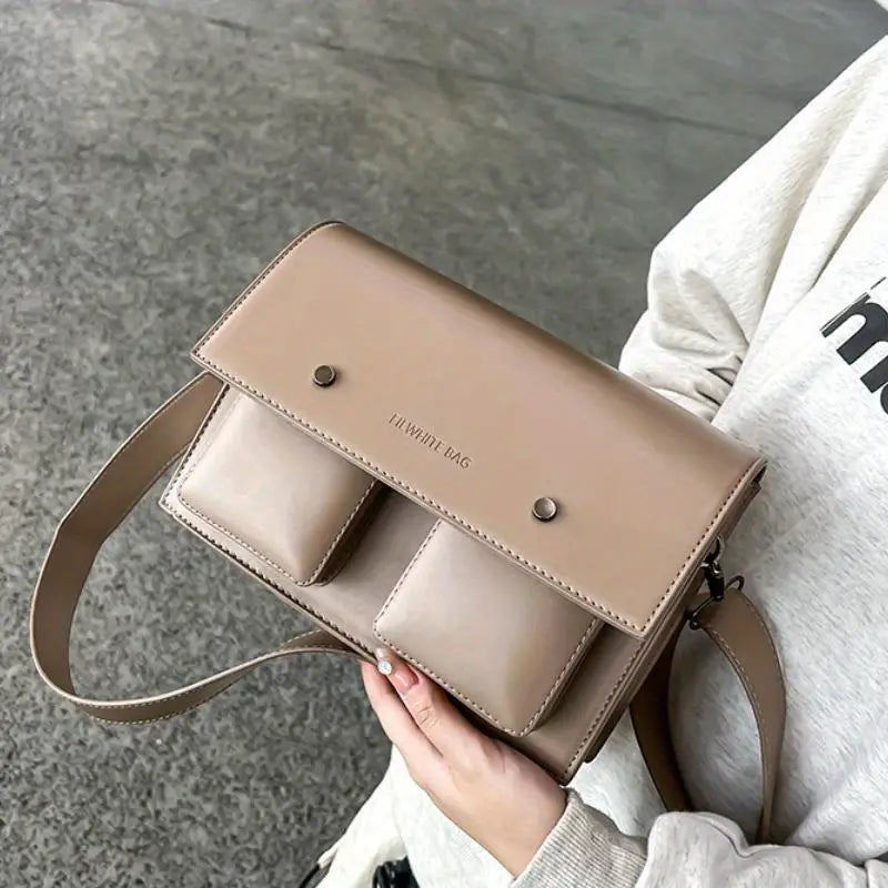 Borsa a tracolla in pelle beige con doppie tasche frontali, design elegante e moderno, perfetta per moda donna e accessori quotidiani.