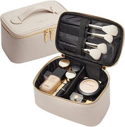Elegante borsa trucco beige con cerniera, contenente pennelli e cosmetici di lusso. Ideale per organizzare il make-up in viaggio.