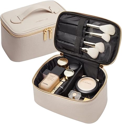 Elegante borsa trucco beige con cerniera, contenente pennelli e cosmetici di lusso. Ideale per organizzare il make-up in viaggio.