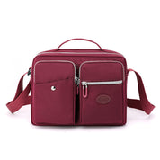 Borsa a tracolla rossa in nylon con tasche multiple e cerniere, design elegante e funzionale, ideale per donna, moda accessori 2023.