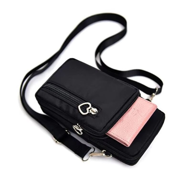 Borsa a tracolla nera con tasca frontale rosa, design compatto, chiusura a zip, ideale per smartphone e accessori, moda donna elegante.