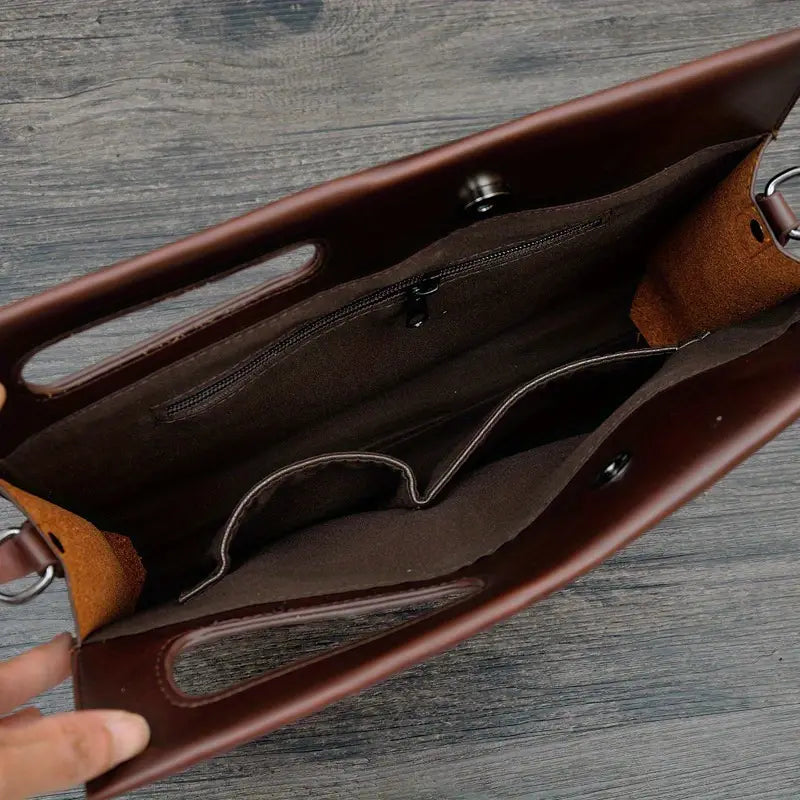 Borsa in pelle marrone con manici, vista dall'alto. Interno spazioso con tasche multiple, ideale per lavoro e uso quotidiano. Elegante e funzionale.