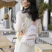 Donna con zaino a tracolla bianco e rosa, design geometrico, all'aperto. Moda casual, accessorio trendy per viaggi e tempo libero.