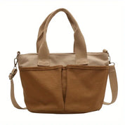 Borsa a tracolla in tela marrone chiaro con manici, tasche frontali e tracolla regolabile. Design casual, ideale per uso quotidiano.