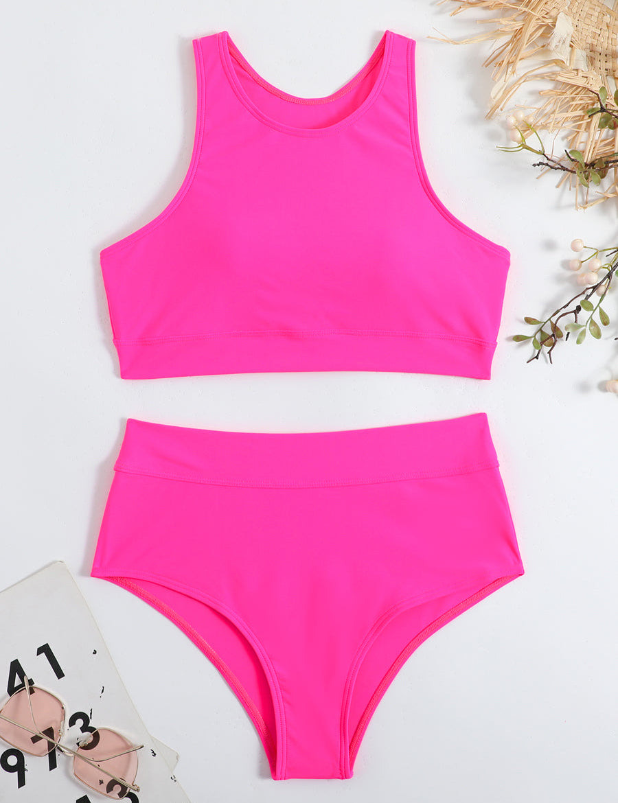 Costume da bagno donna due pezzi rosa fluo, top sportivo e slip a vita alta, su sfondo bianco con occhiali da sole e decorazioni floreali.