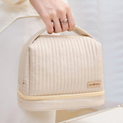 Borsa termica beige con manico, design trapuntato, chiusura a zip, ideale per pranzo al sacco. Accessorio elegante e funzionale per ufficio o viaggio.