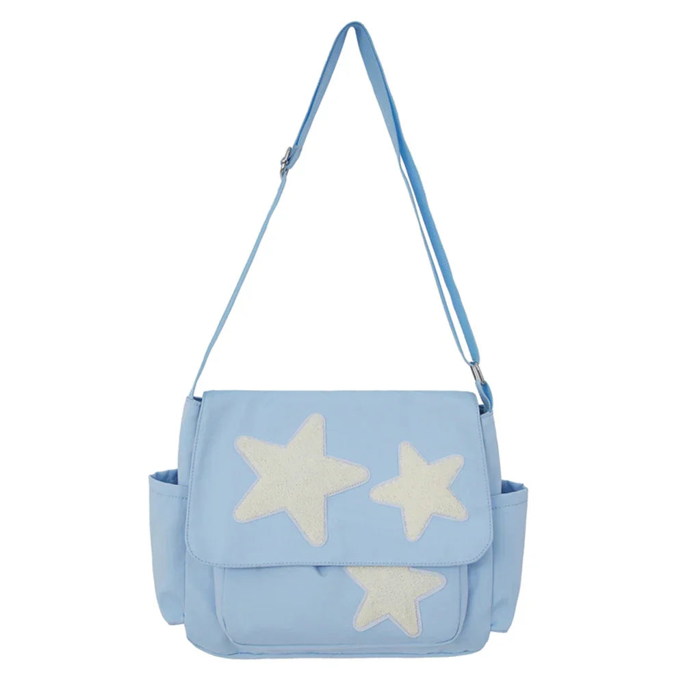 Borsa a tracolla azzurra con stelle bianche, tasche laterali, design moderno. Accessorio moda donna, ideale per uso quotidiano e casual.