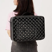 Zaino nero trapuntato in pelle lucida, indossato da una donna. Design elegante e moderno, ideale per moda e viaggi.