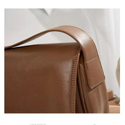 Borsa a tracolla in pelle marrone, design elegante e minimalista, perfetta per moda uomo e donna, accessorio versatile e di tendenza.