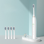 Spazzolino elettrico bianco con quattro testine di ricambio su base moderna, design minimalista, ideale per igiene orale avanzata e pulizia dentale efficace.