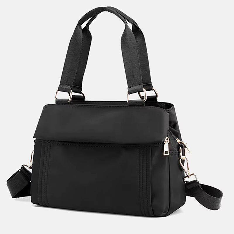 Borsa a tracolla nera in nylon impermeabile, design elegante con manici robusti e cerniere dorate, ideale per donna, moda e praticità quotidiana.