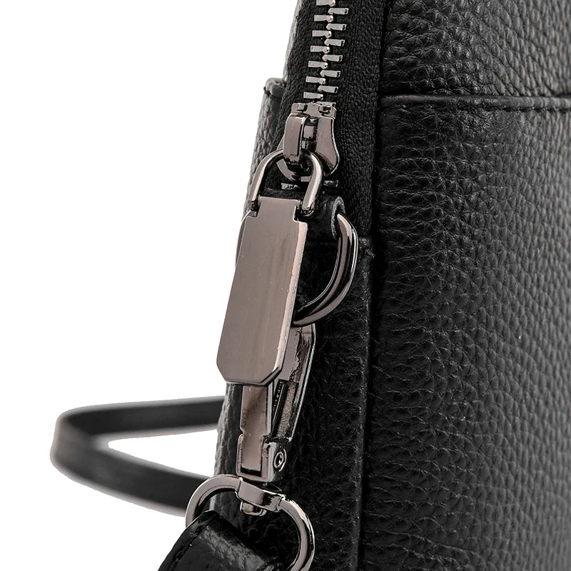 Borsa a tracolla in pelle nera con chiusura a zip e dettagli metallici argentati. Design elegante e moderno, ideale per moda femminile.
