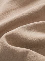 Tessuto di lino beige, trama naturale, texture morbida e ondulata, ideale per abbigliamento e arredamento, alta qualità e resistenza.