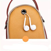 Zaino in pelle gialla con foro per auricolari bianchi, design compatto, ideale per viaggi e uso quotidiano. Accessorio moda pratico e funzionale.