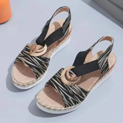 Sandali estivi donna con zeppa, motivo zebrato, cinturino elastico nero, decorazione dorata, suola in corda intrecciata, eleganti e comodi.