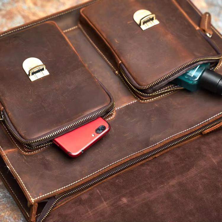 Borsa in pelle marrone con tasche, smartphone rosso e flacone di gel igienizzante. Accessorio elegante e funzionale per lavoro e viaggio.