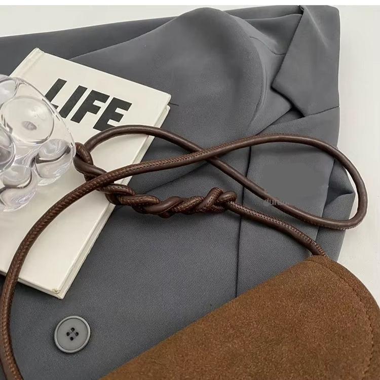 Giacca grigia elegante con libro "LIFE", borsa marrone e accessorio trasparente. Moda autunnale, abbigliamento casual chic, stile contemporaneo.