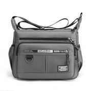 Borsa a tracolla grigia unisex, design moderno, tasche multiple con zip, ideale per viaggio e lavoro. Materiale resistente e impermeabile.