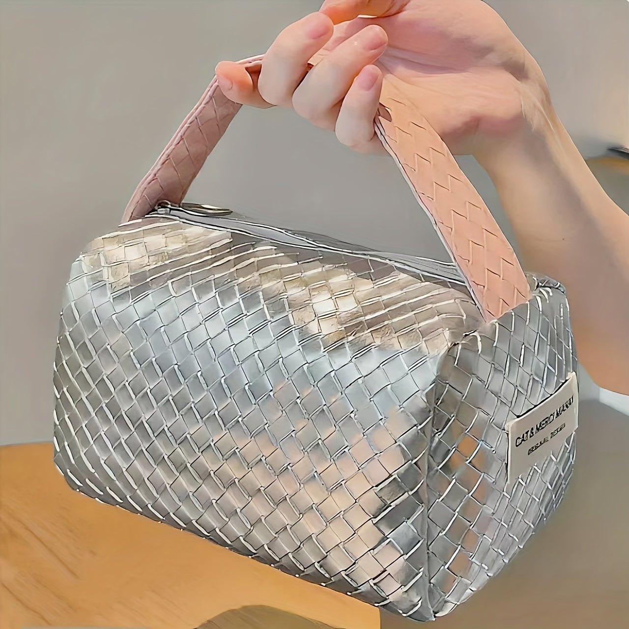 Borsa a mano intrecciata argento con manico rosa, design elegante e moderno, ideale per moda femminile e accessori di tendenza.