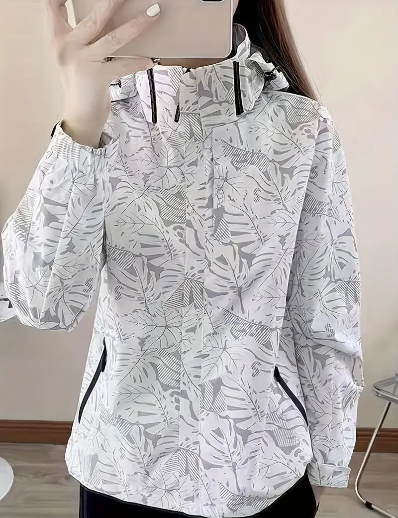 Giacca a vento donna bianca con stampa foglie tropicali, cappuccio regolabile, tasche con zip, ideale per attività outdoor e moda casual.
