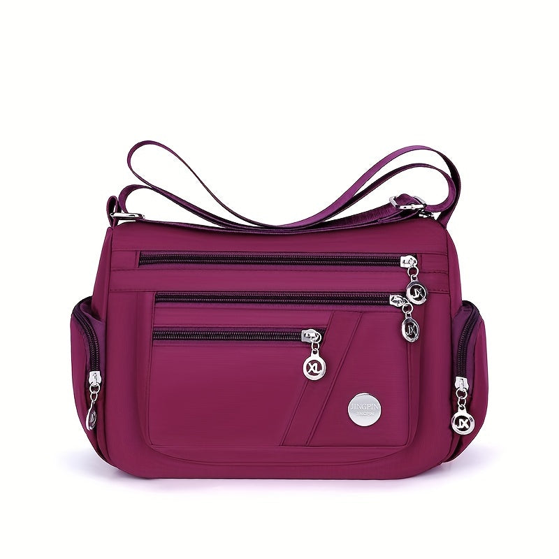Borsa a tracolla viola con tasche multiple e cerniere, design elegante e pratico, perfetta per uso quotidiano e viaggi. Accessorio moda donna.