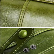 Dettaglio di una borsa in pelle verde con cuciture visibili e chiusure metalliche. Accessorio moda elegante e di alta qualità.