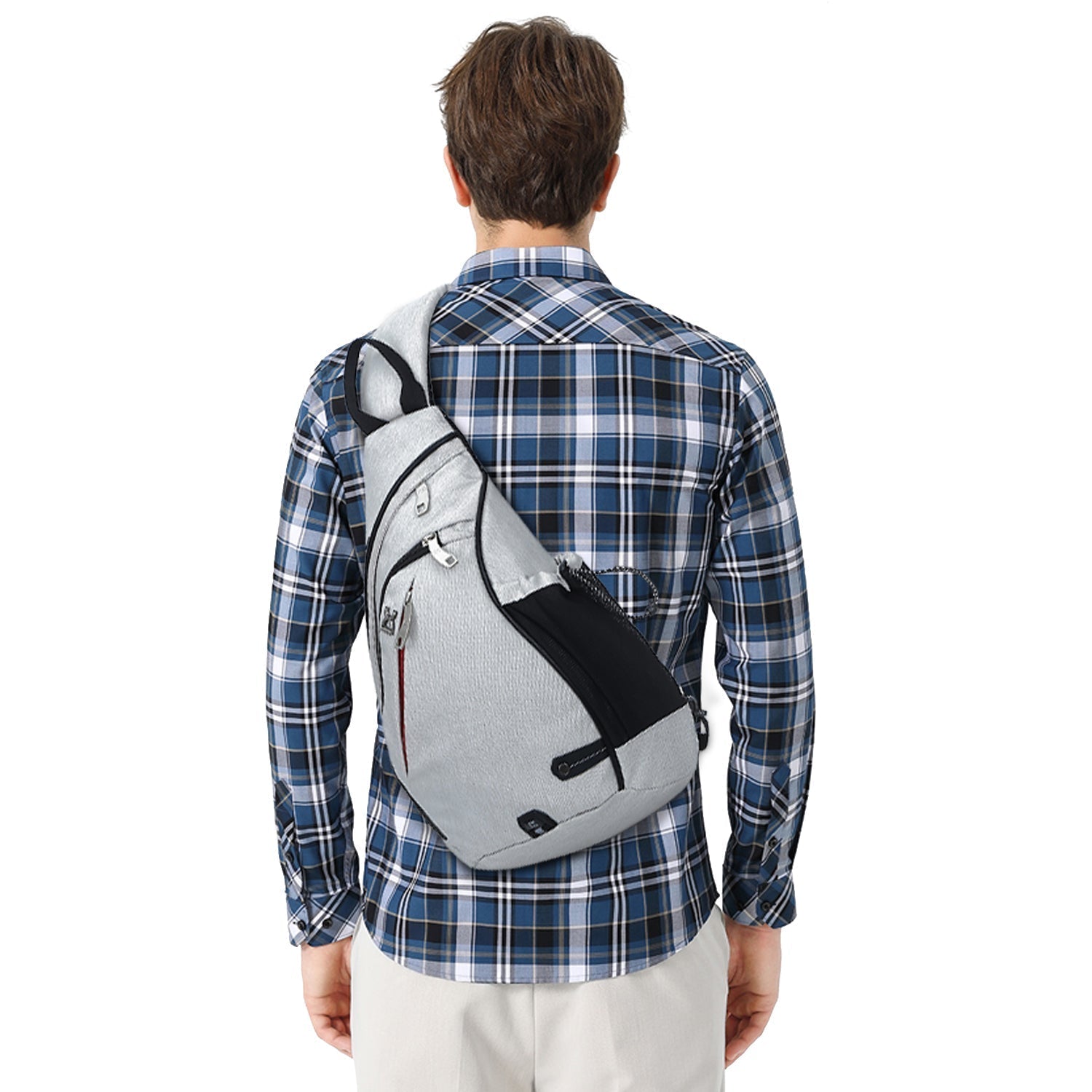 Uomo con zaino monospalla grigio, design moderno, indossa camicia a quadri blu. Accessorio moda casual, ideale per viaggi e uso quotidiano.