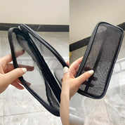 Astuccio trasparente in rete nera con cerniera, ideale per organizzare penne e accessori. Design elegante e pratico per scuola o ufficio.