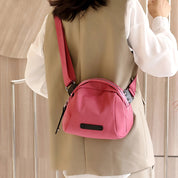 Donna con borsa a tracolla rosa, design moderno, indossa gilet beige e camicia bianca. Accessorio moda femminile, stile casual chic.