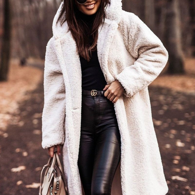 Cappotto in pelliccia sintetica bianca, donna con pantaloni in pelle nera, borsa beige, autunno, moda femminile, stile casual elegante.