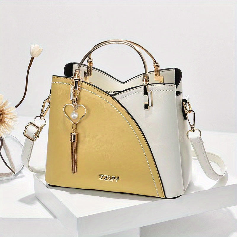 Borsa a mano elegante in pelle bicolore bianca e gialla, con manico dorato e ciondolo a cuore, perfetta per moda femminile e accessori di lusso.