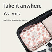 Valigia aperta con organizer da viaggio rosa a fantasia, ideale per bagagli ordinati. Perfetto per viaggi, accessori, organizzazione valigia.