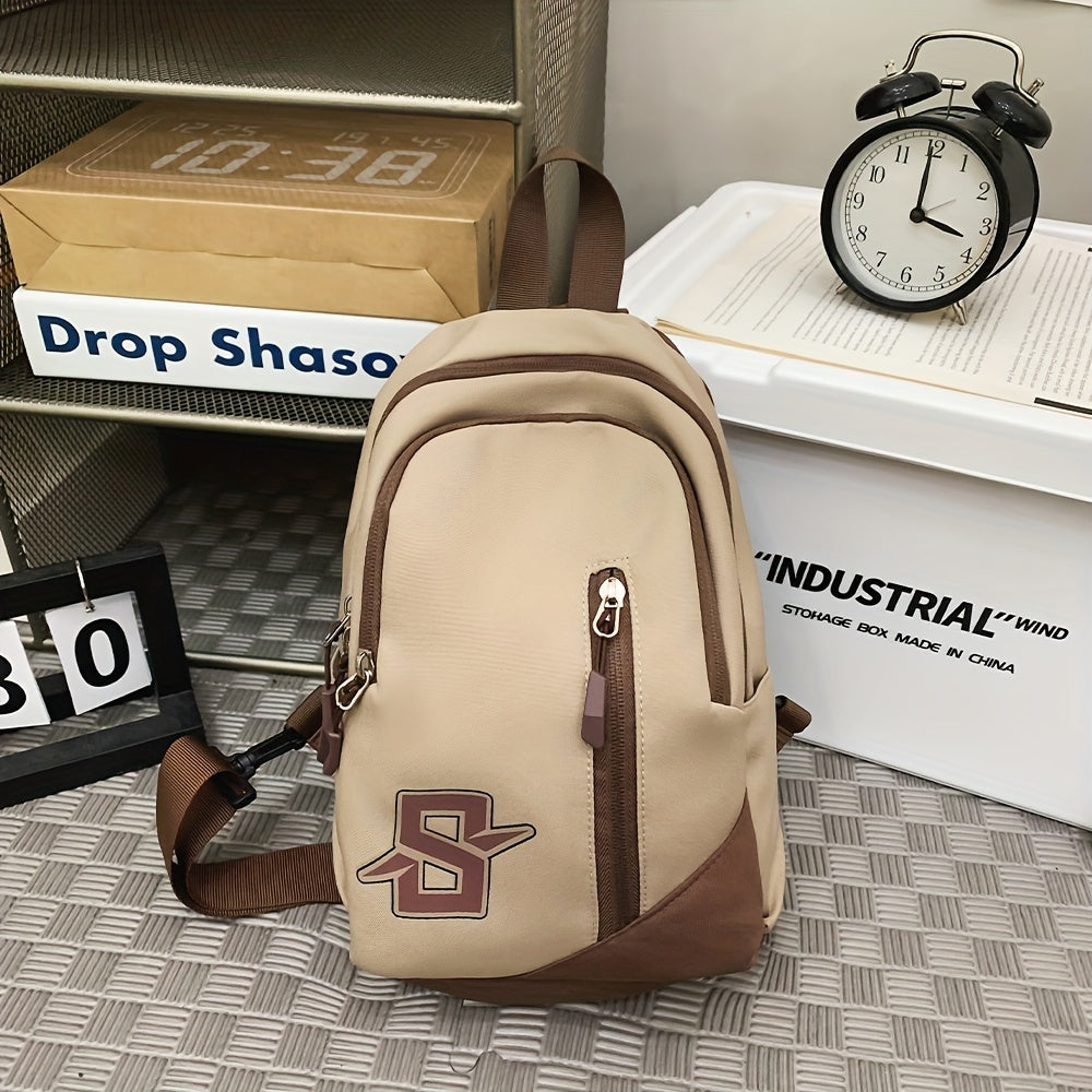 Zaino beige e marrone con logo, tasche multiple, su scaffale industriale. Orologio vintage e scatole sullo sfondo. Accessorio moda casual.