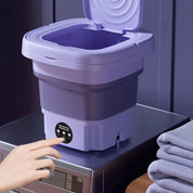 Lavatrice portatile pieghevole viola su lavatrice, design compatto, ideale per piccoli spazi, perfetta per viaggi e camper.