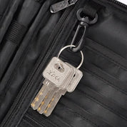Portachiavi con tre chiavi argentate attaccato a una borsa nera con cerniera. Accessorio pratico per organizzazione e sicurezza.