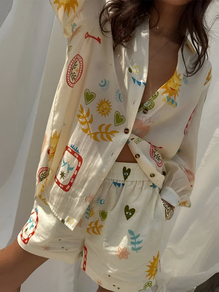 Camicia e pantaloncini in seta con stampa colorata di cuori, sole e foglie. Moda estiva donna, abbigliamento casual elegante.